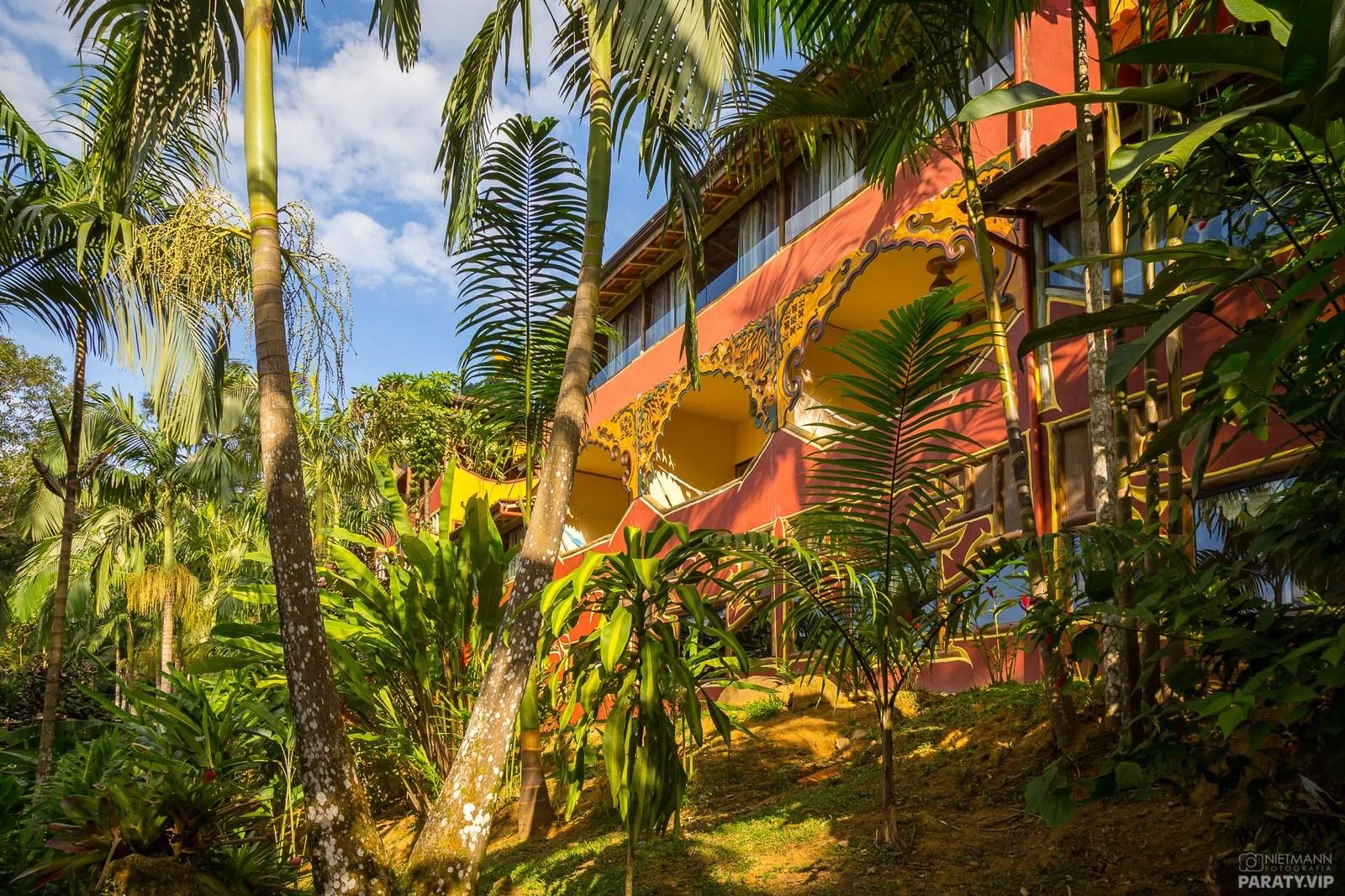 O pavilhão principal do Dharma Shala visto do jardim, entre palmeiras e mata nativa